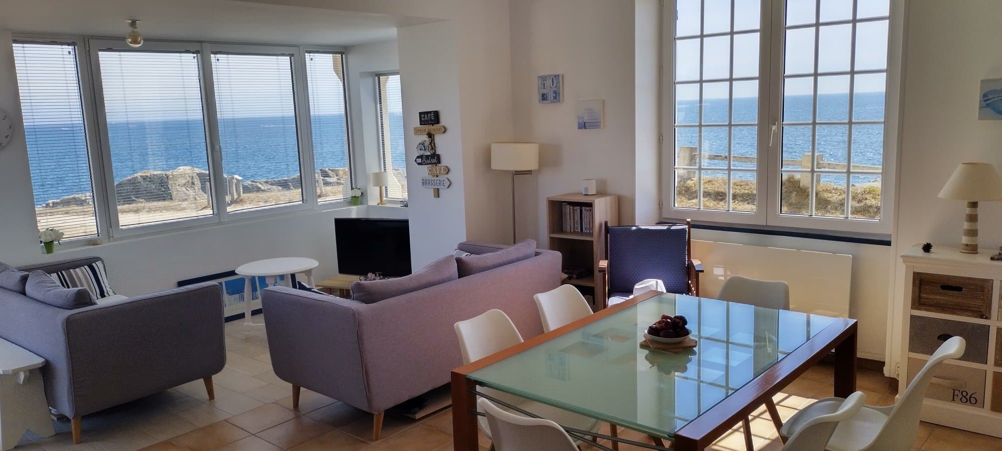 Le séjour et la salle à manger, avec la mer derrière chaque fenêtre